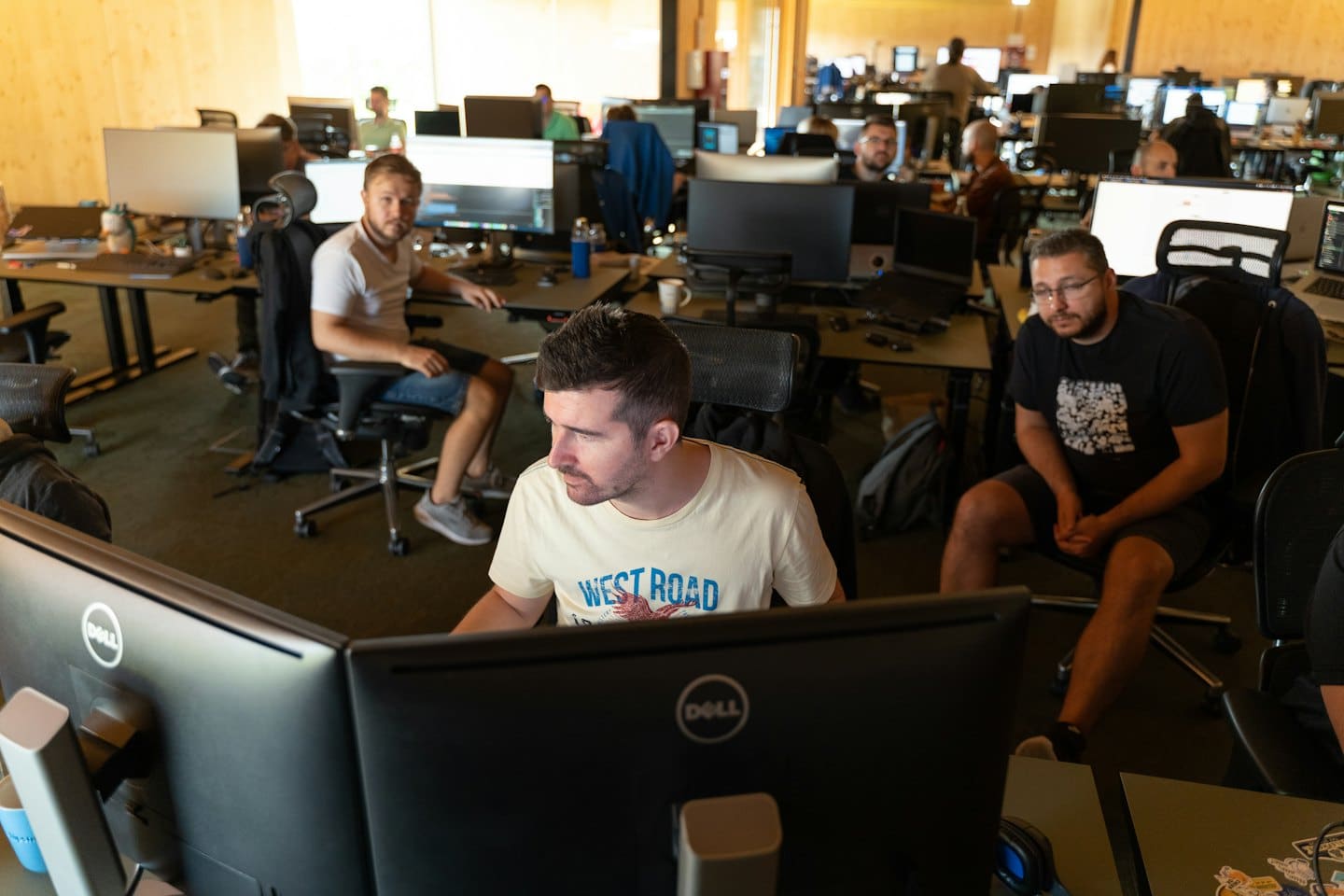 Professionisti IT che collaborano alle loro scrivanie in un ufficio moderno.